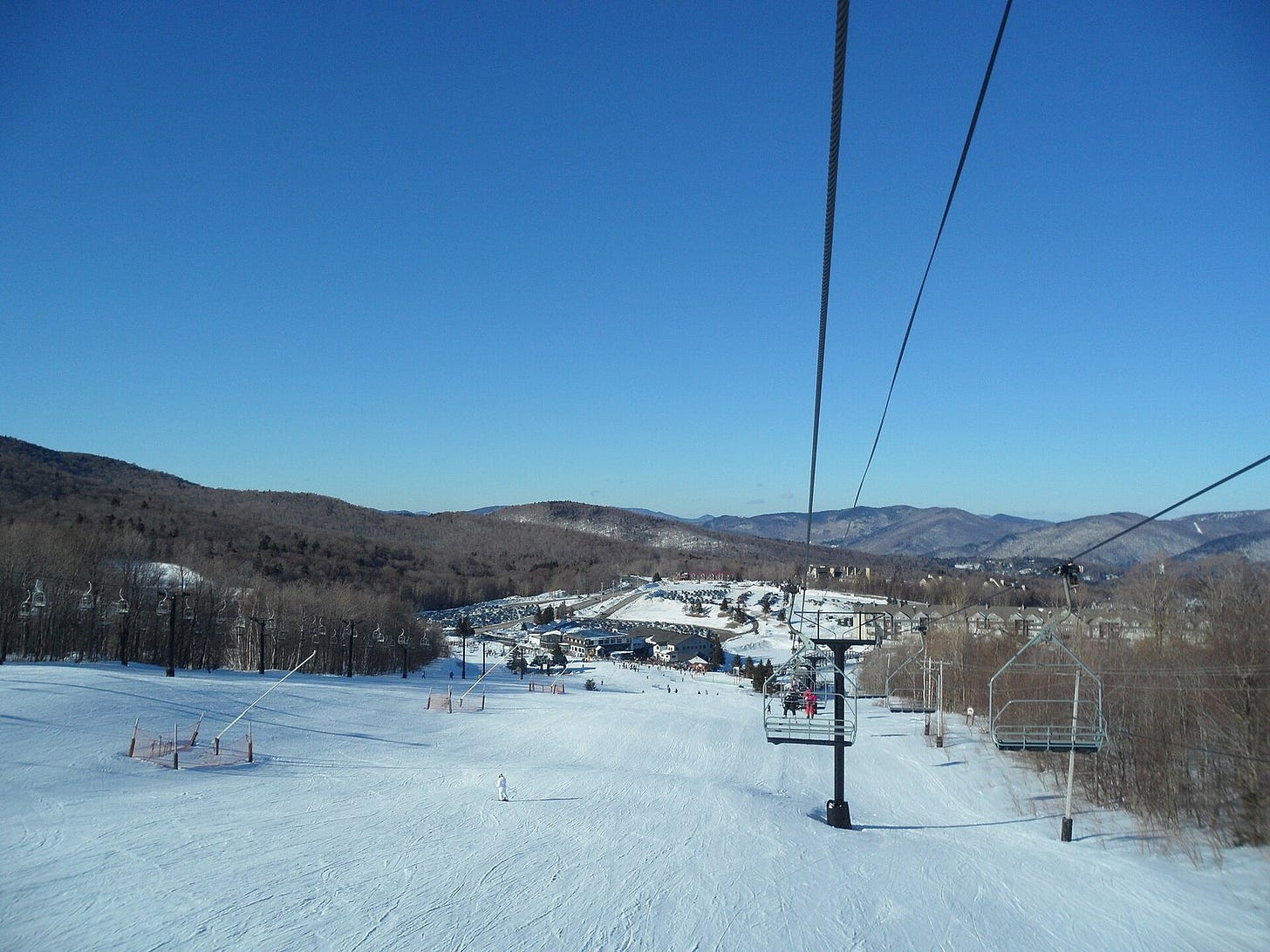 View from a chairlift down a groomed run to the Snowshed base lodge at Killington