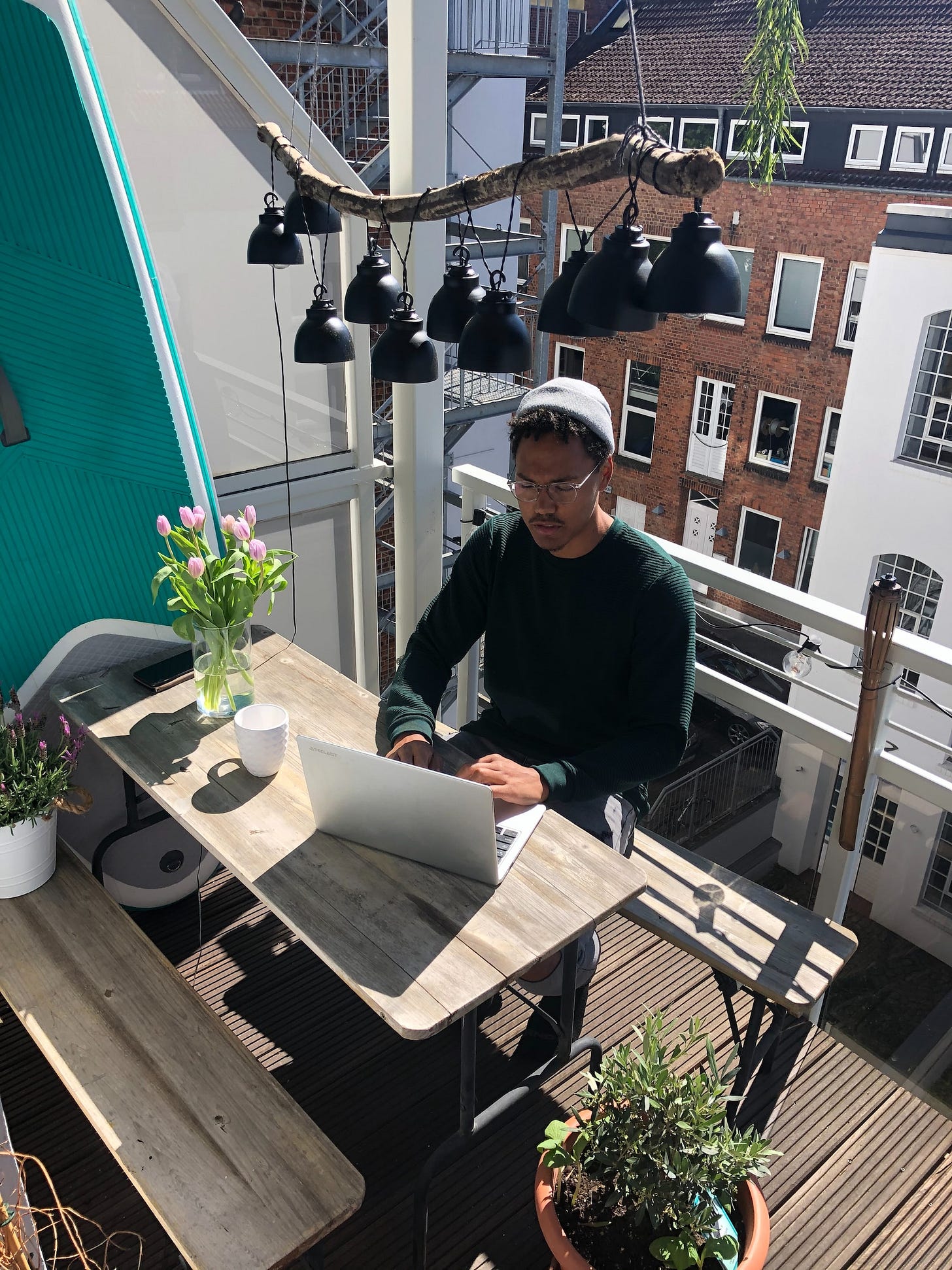 A man working on a balcony in an urban environment