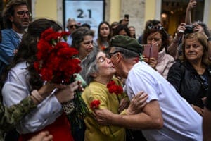 Ninety-year-old Celeste Caeiro, who handed red carnations to the military taking part in the Portuguese revolution on 25 April 1974, greets a former soldier during a military parade to celebrate the anniversary on Thursday Ninety-year-old Celeste Caeiro, who handed red carnations to the military taking part in the Portuguese revolution on 25 April 1974, greets a former soldier during a military parade to celebrate the anniversary on Thursday