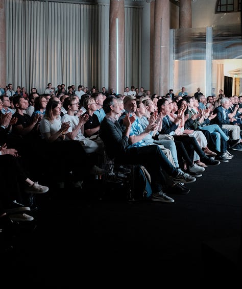 A gallery of 6 images showing close ups of the audience and zoomed out photographs of the Sana AI Summit stage.