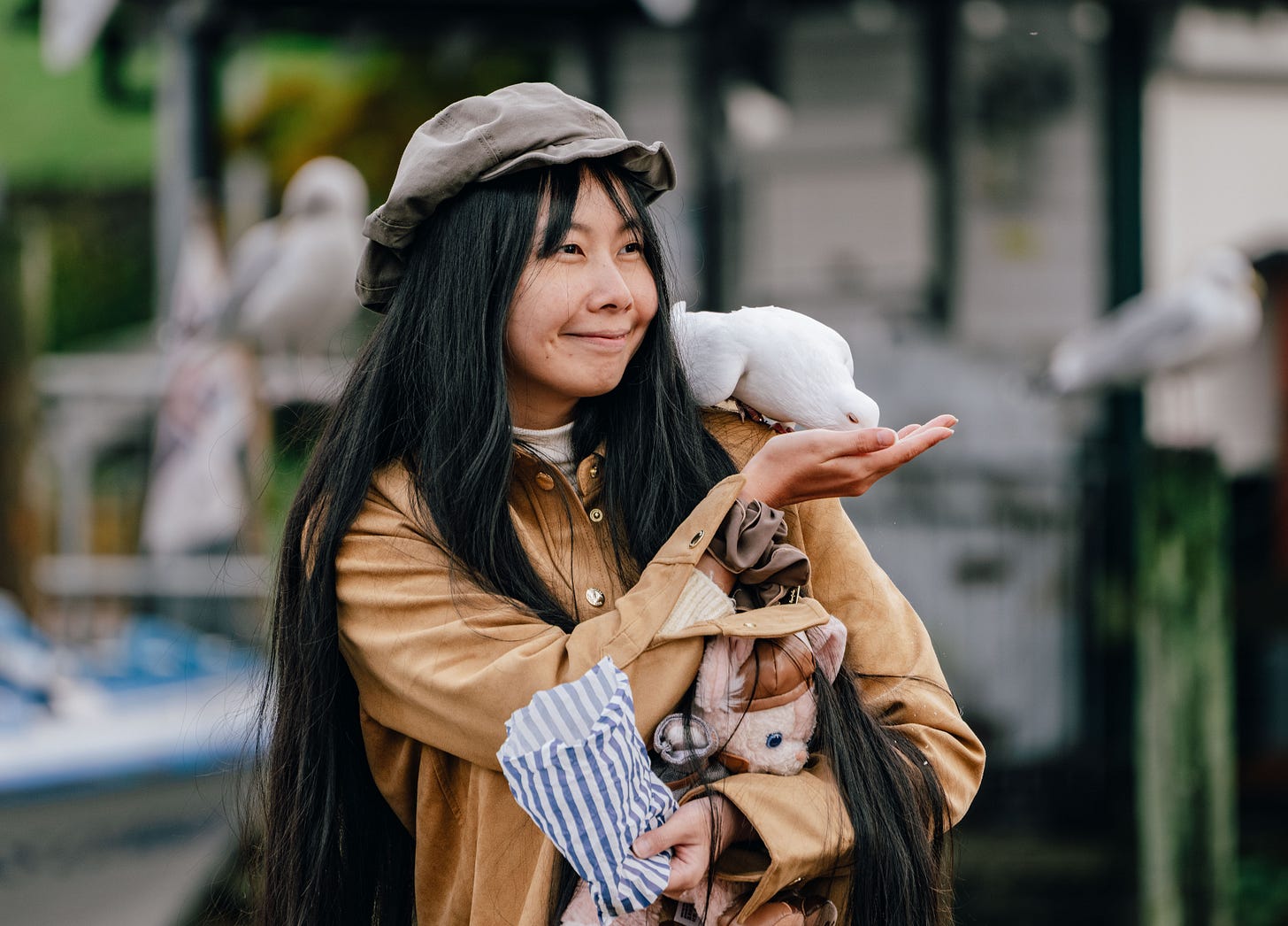 Woman feeding a white dove in the Lake District, England, outdoor candid portrait with birds, UK travel photography. Woman feeding a white dove in the Lake District, England, outdoor candid portrait with birds, UK travel photography.