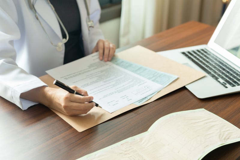 A doctor fills in some forms
