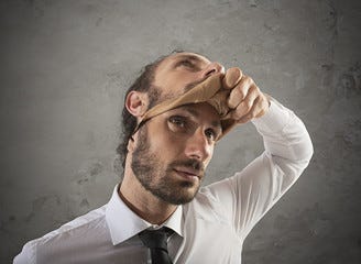 Businessman that removes the mask. Concept of falsity