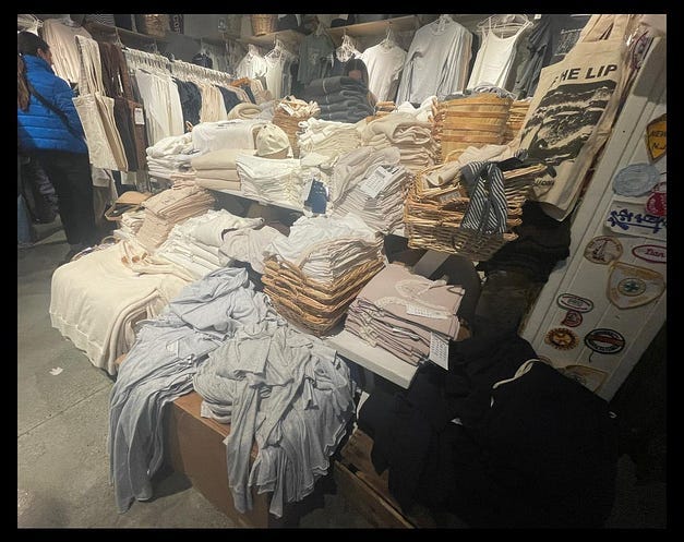 A messy pile of neutral clothes in an interesting looking shop. That’s Brandy Melville.