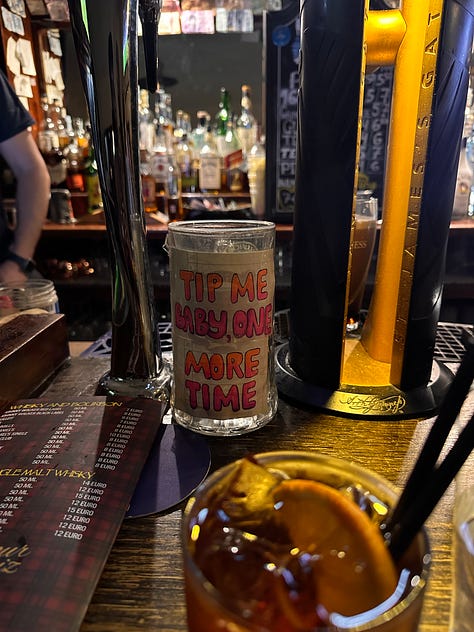 A negroni and a cup of water, my bar crawl group and a tip jar