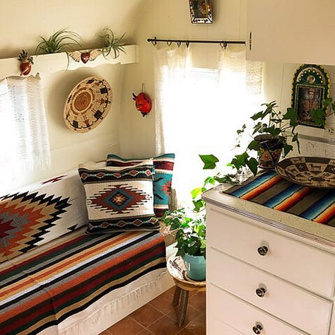 Vintage trailer painted orange turquoise and cream decorated with Mexican blankets and rugs