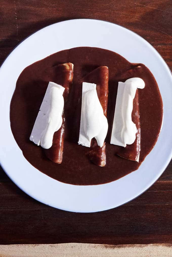 Plate of enchiladas with beans sauce, enfrijoladas de jamon