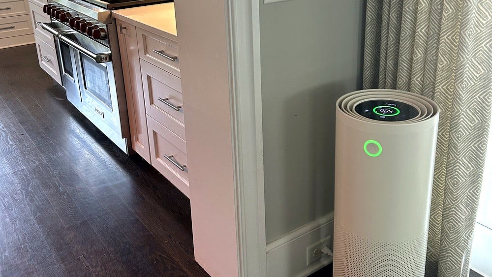 A Jaspr air purifier with a green status ring standing in a kitchen A Jaspr air purifier with a green status ring standing in a kitchen