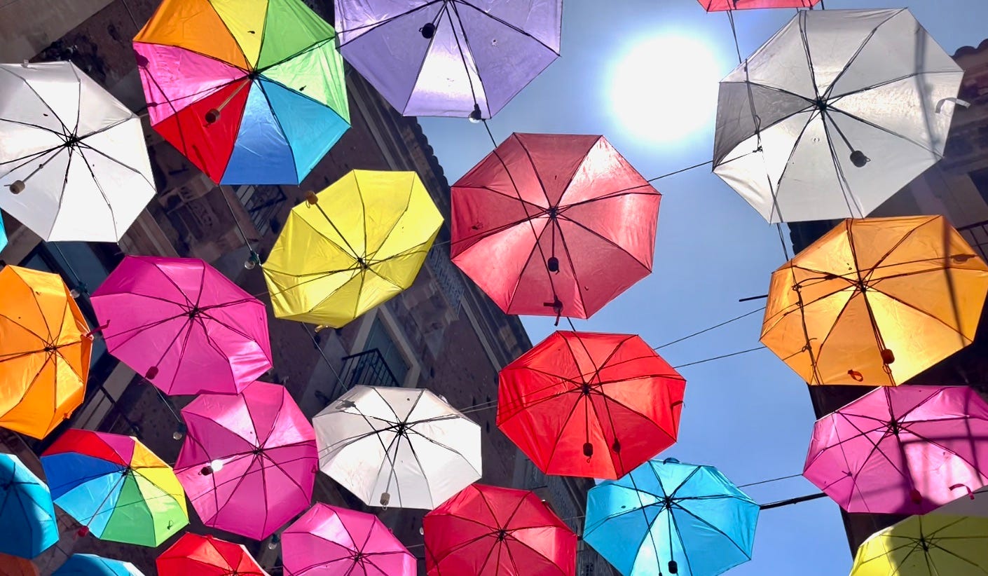 Lots of multi coloured umbrellas overhead