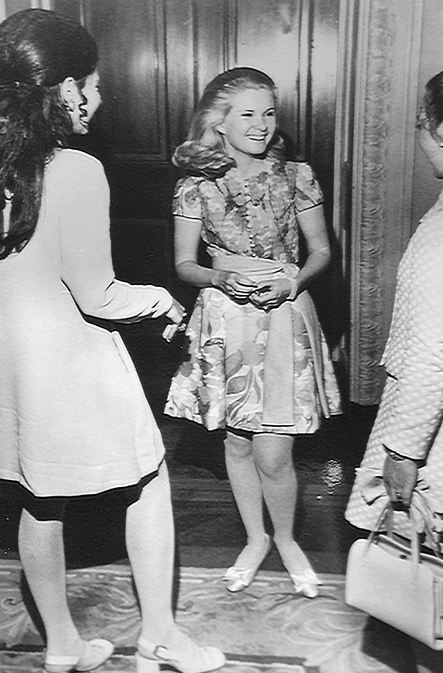The three squarest young women in the whole world in the late 60s/early 70s stand around smiling in their party dresses. To be fair to them, they do look happy