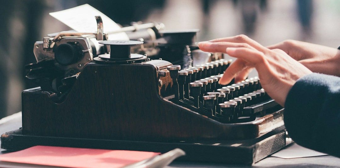 person using black typewriter