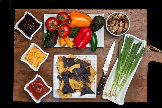 Simple lay flat food photo depicting nacho ingredients on a cutting board