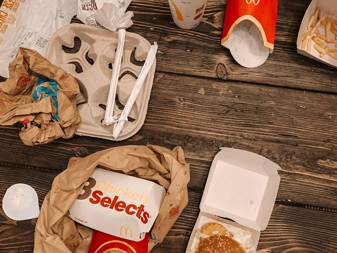 white and red plastic container beside brown paper bag