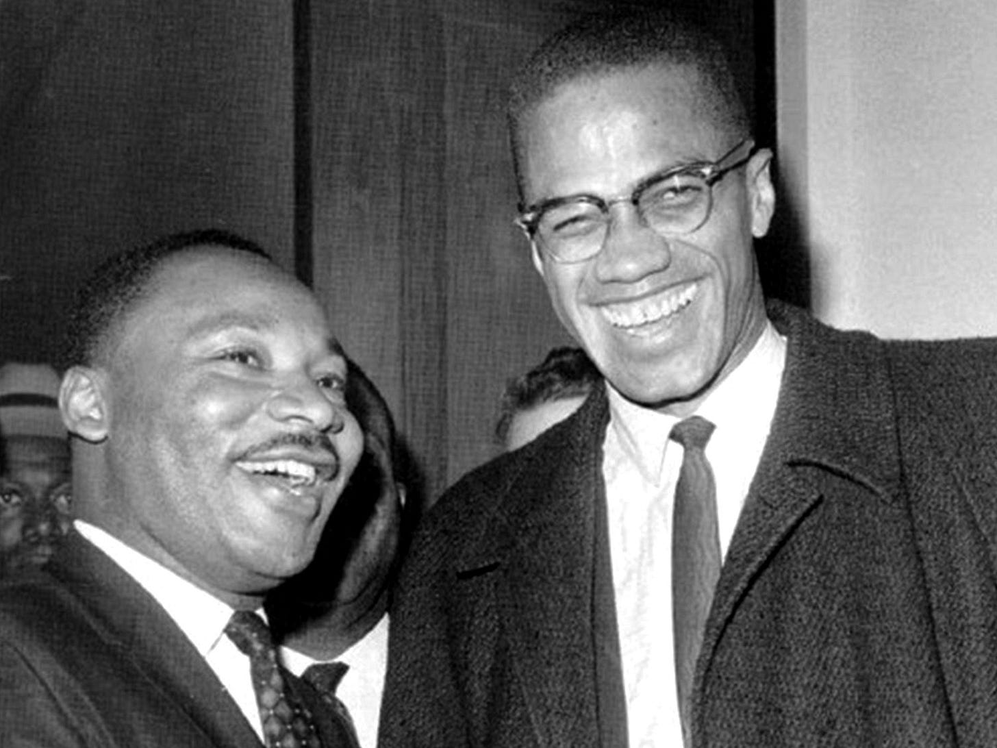 This black-and-white image shows one of the only known photographs of Dr. Martin Luther King, Jr. (left) and Malcolm X (right) ever taken together. Snapped on 26 March 1964, this photo shows both men smiling broadly at the camera while standing in a corridor of the United States Senate Building in Washington, D.C. during a break from hearings over the proposed Civil Rights Act of 1964. This black-and-white image shows one of the only known photographs of Dr. Martin Luther King, Jr. (left) and Malcolm X (right) ever taken together. Snapped on 26 March 1964, this photo shows both men smiling broadly at the camera while standing in a corridor of the United States Senate Building in Washington, D.C. during a break from hearings over the proposed Civil Rights Act of 1964.