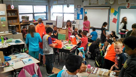Students working on various projects throughout a classroom. 
