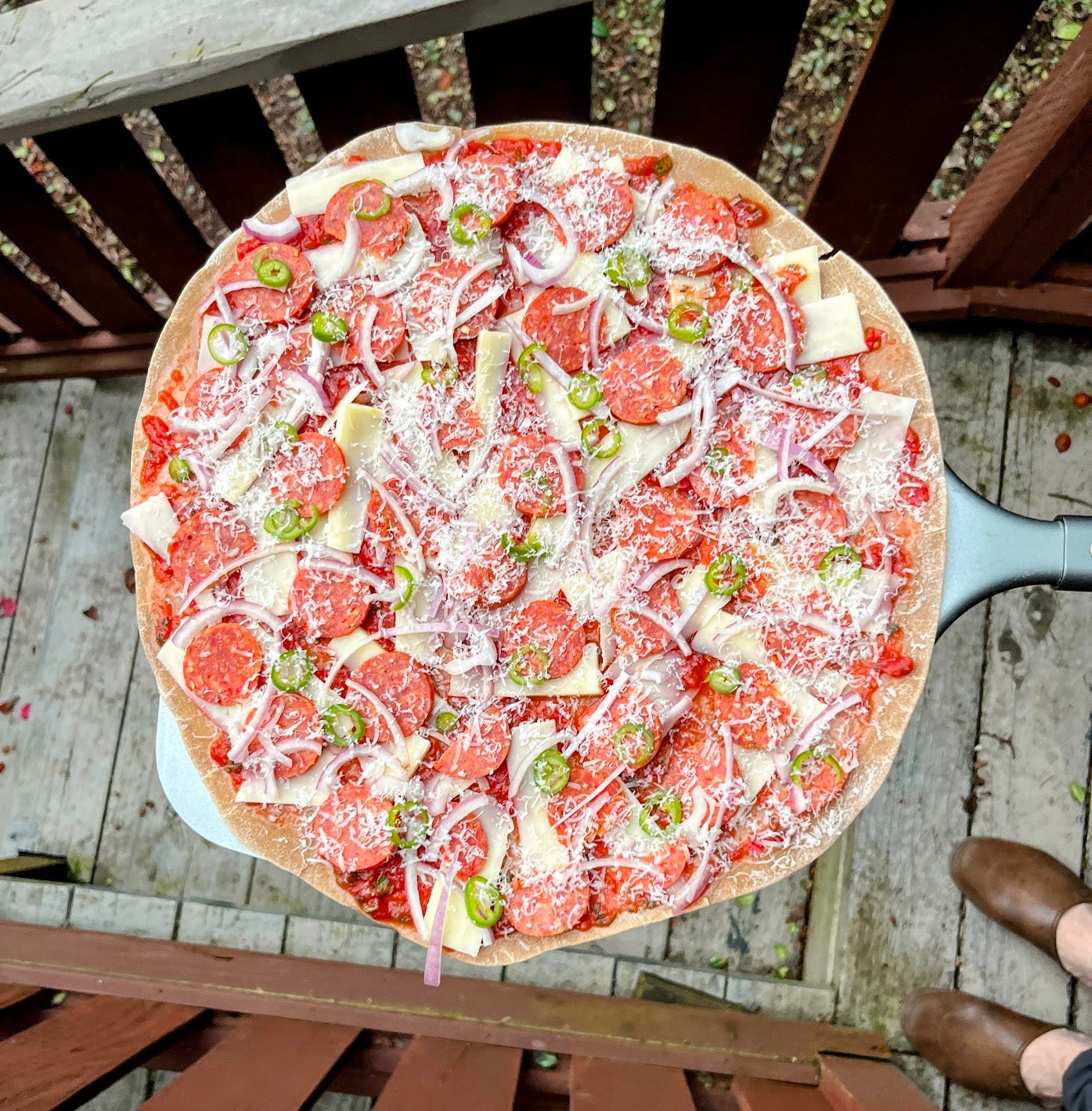 Uncooked tavern-style pizza on a peel