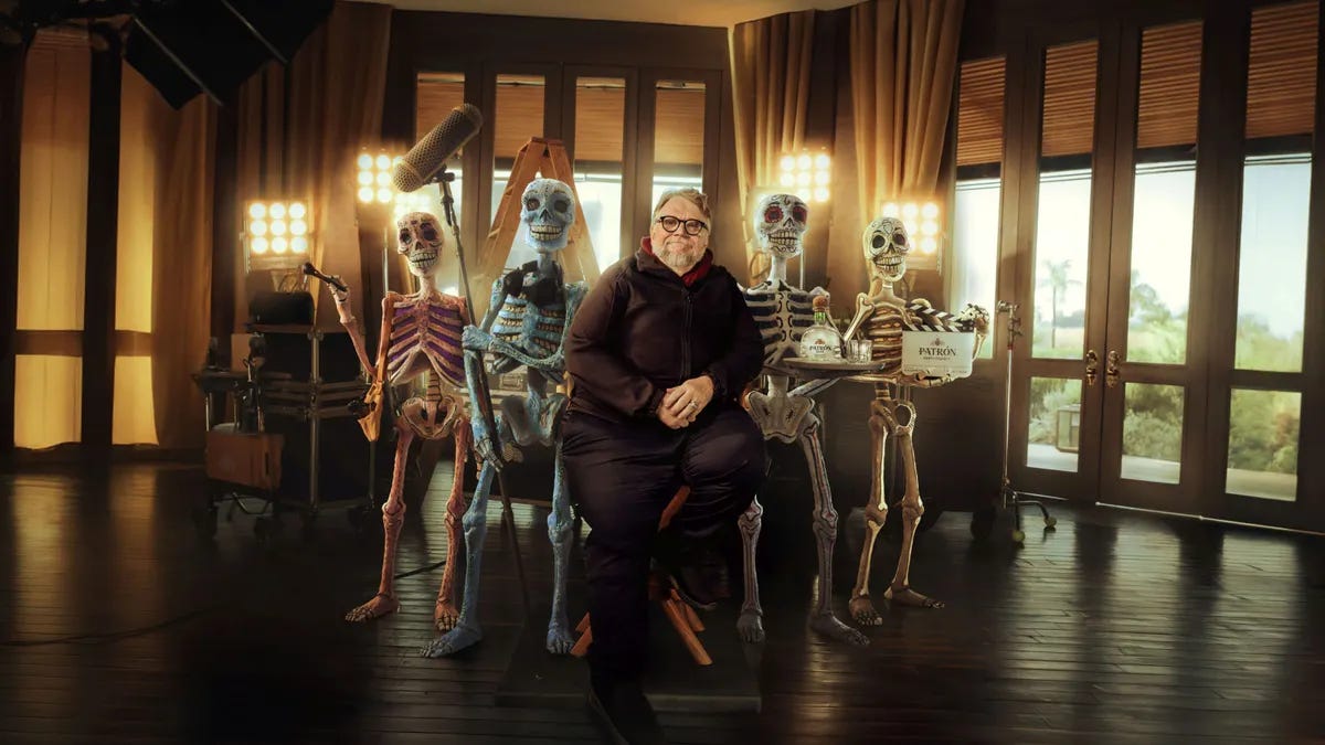 Filmmaker Guillermo del Toro sits on a chair, flanked by a team of skeletons Filmmaker Guillermo del Toro sits on a chair, flanked by a team of skeletons