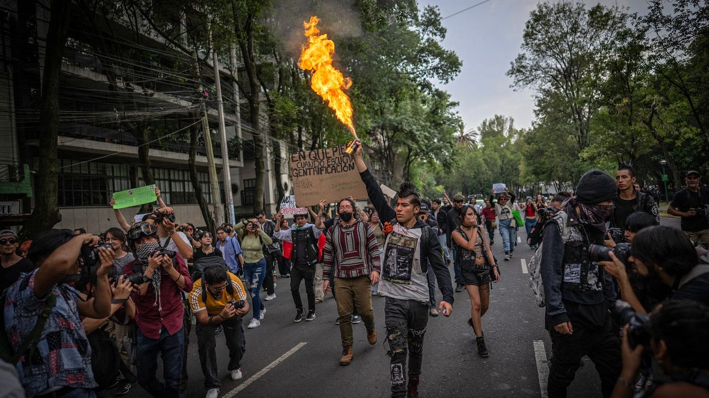A protestor lights an aerosol can during a protest against gentrification in Mexico City, on July 4.