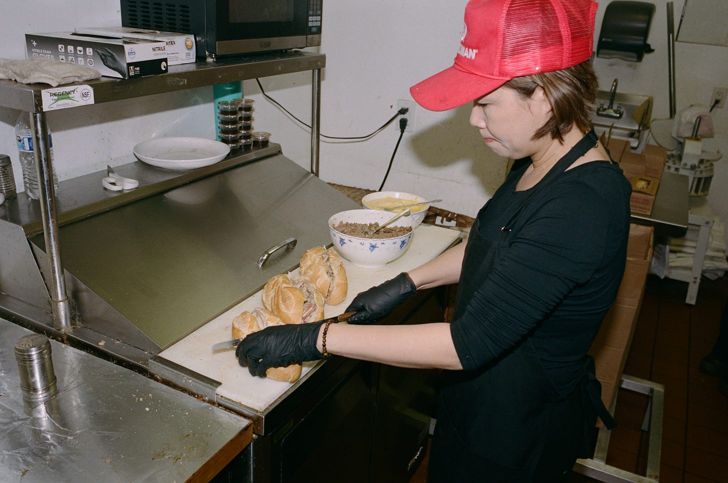 A staff member assembles sandwiches
