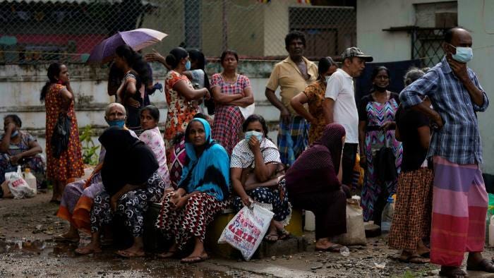 Residents wait at a fuel station to buy kerosene oil for cooking in Colombo