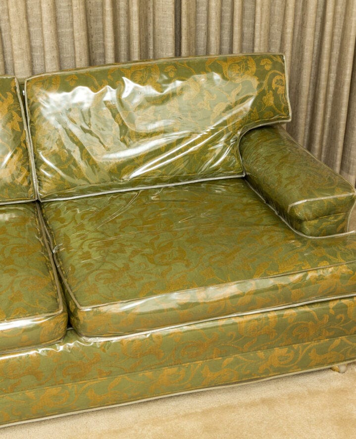 Plastic furniture cover on a green sofa. Plastic furniture cover on a green sofa.