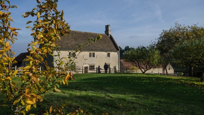 View of Woolsthorpe Manor from the back of the orchard, with leaves on the ground View of Woolsthorpe Manor from the back of the orchard, with leaves on the ground