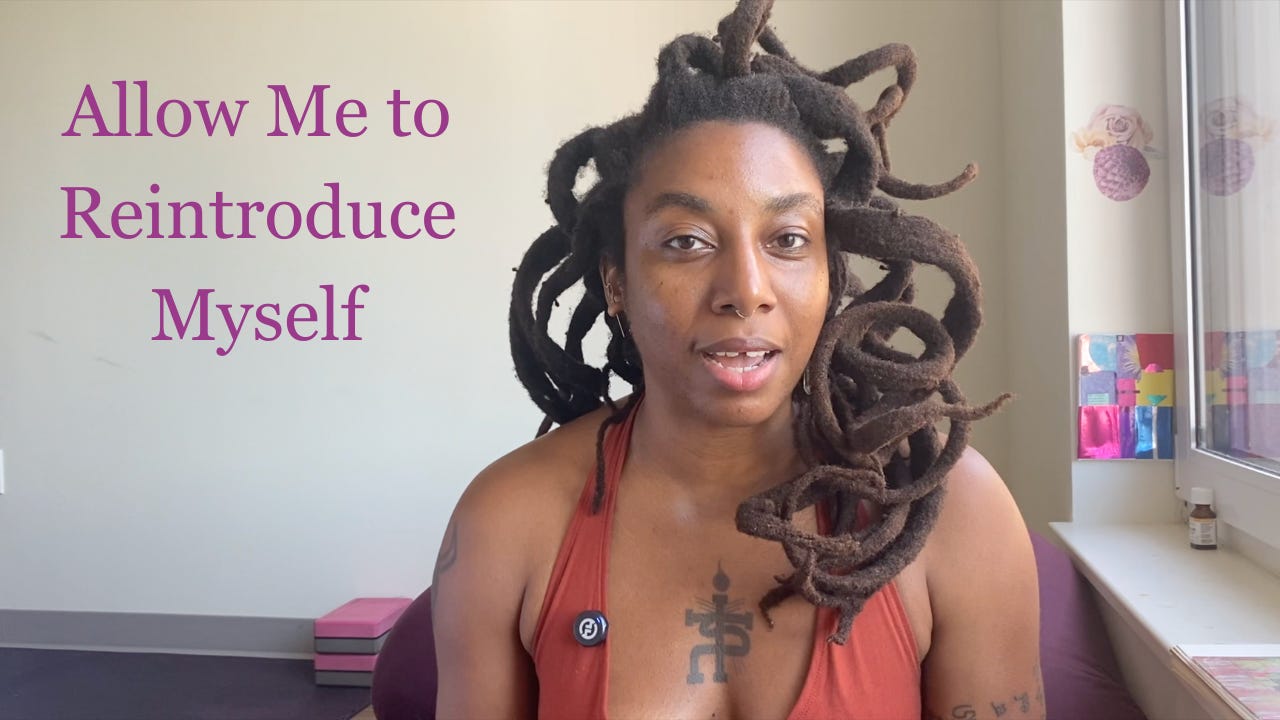 beautiful black woman with thick curly freeform locs speaking into a camera. The text next to her says "Allow me to reintroduce myself"