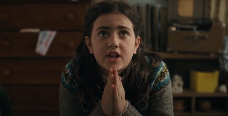 A young girl looks upward with her hands clasped in prayer. A young girl looks upward with her hands clasped in prayer.