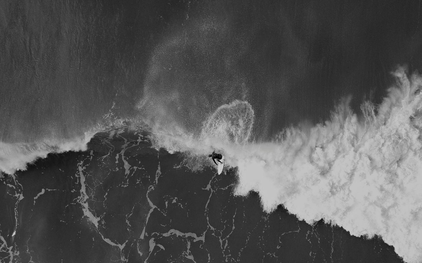 una persona che fa surf su una tavola bianca fotografato dall'alto mentre cavalca l'onda una persona che fa surf su una tavola bianca fotografato dall'alto mentre cavalca l'onda