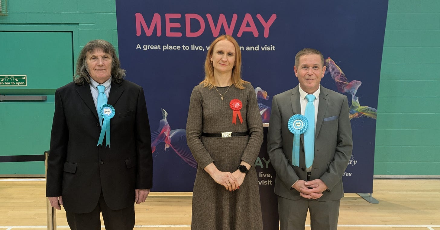Three people stood smiling at the camera. Three people stood smiling at the camera.