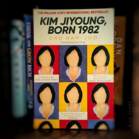 The book ‘Kim Jiyoung born 1982’ in a bookshelf with a cover image that has graphics of faceless women.