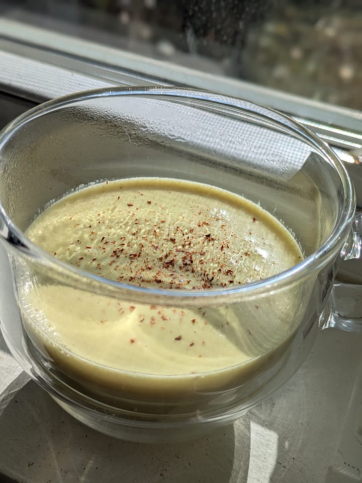 Golden milk ready to drink. Fresh grated turmeric and ginger with ground cinnamon and cardamom, honey and coconut milk getting ready to simmer.