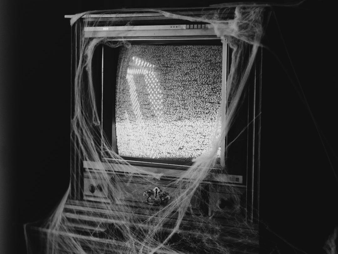 An old TV covered in cobwebs and static.