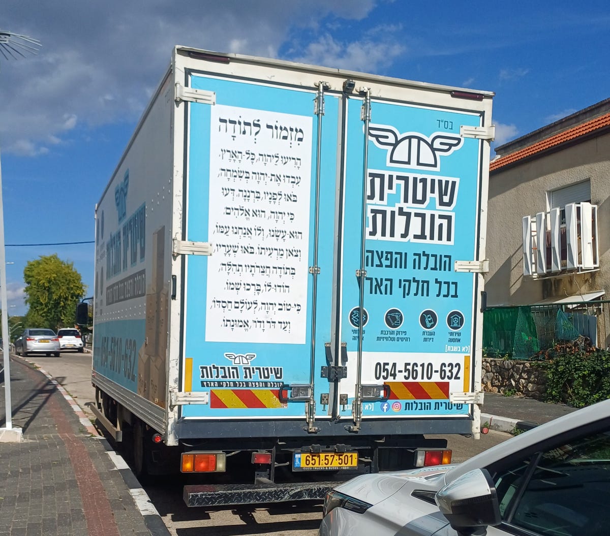 Moving van with Psalm 100 printed on the left-hand door of the back of the truck.