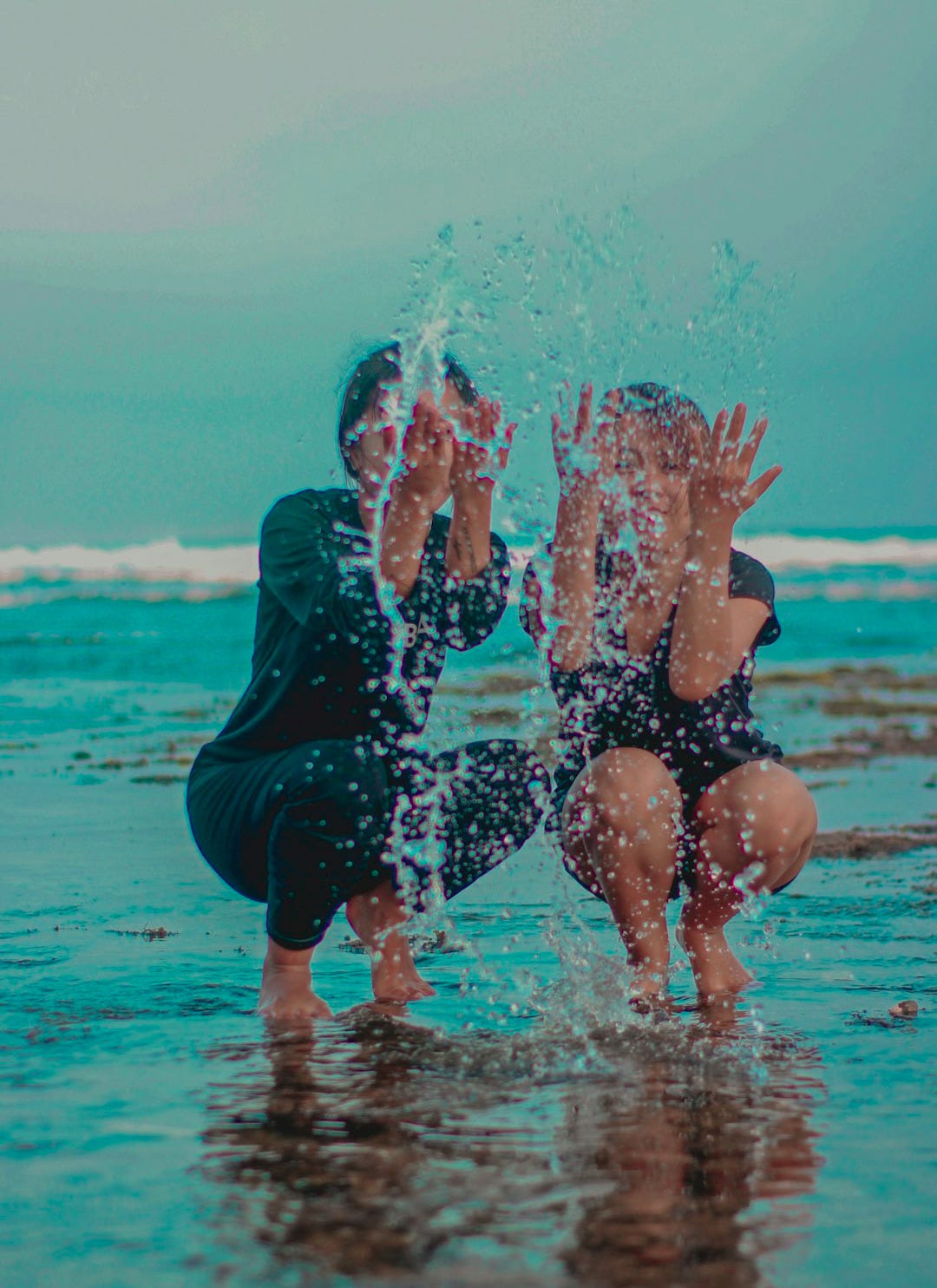 woman in black swimsuit playing with water woman in black swimsuit playing with water