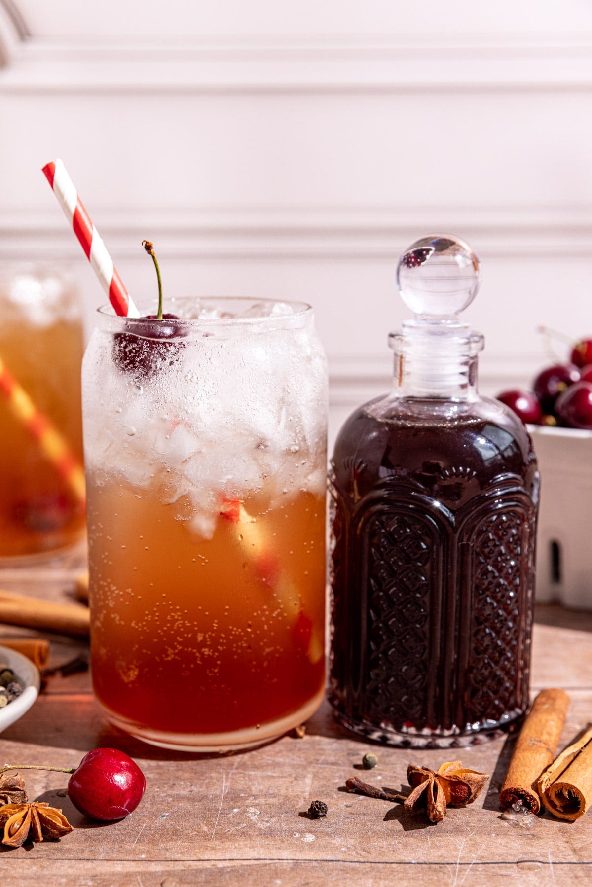 A soda glass of homemade Dr. Pepper with a jar of Dr. Pepper syrup. A soda glass of homemade Dr. Pepper with a jar of Dr. Pepper syrup.