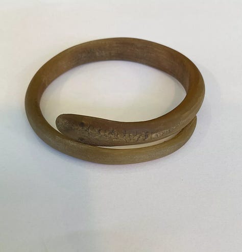 Stylized snake forms beginning in horn or shell are remade in early plastic approximations of natural materials.