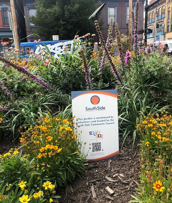 Sign in the volunteer managed community flower beds.