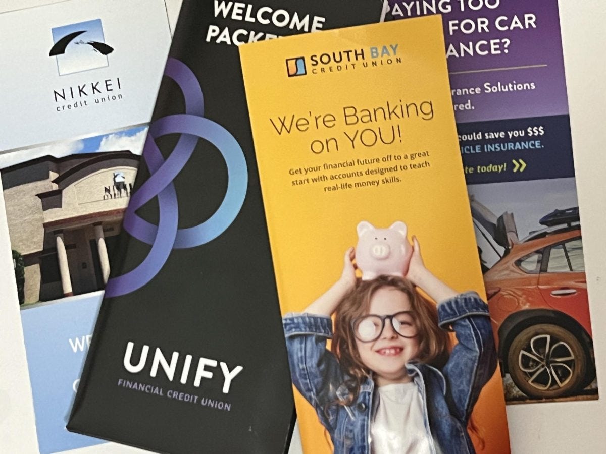 Credit unions in the South Bay offer resources for their members, including college students. (L-R) Pamphlets include Nikkei Credit Union, Unify Credit Union and South Bay Credit Union. (Jamila Zaki | The Union)