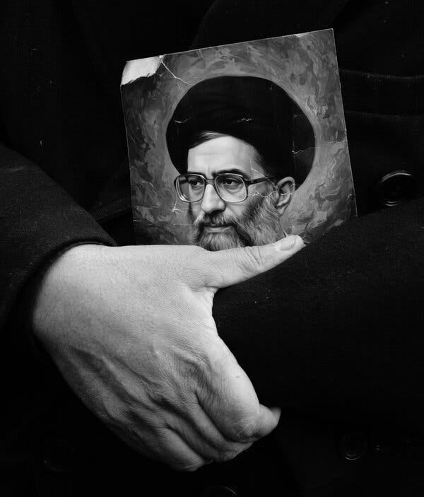 Foto en blanco y negro de una persona sosteniendo un cartel del ayatolá Alí Jamení. Foto en blanco y negro de una persona sosteniendo un cartel del ayatolá Alí Jamení.