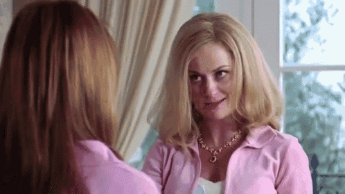 two women are standing next to each other in a room and looking at each other . two women are standing next to each other in a room and looking at each other .