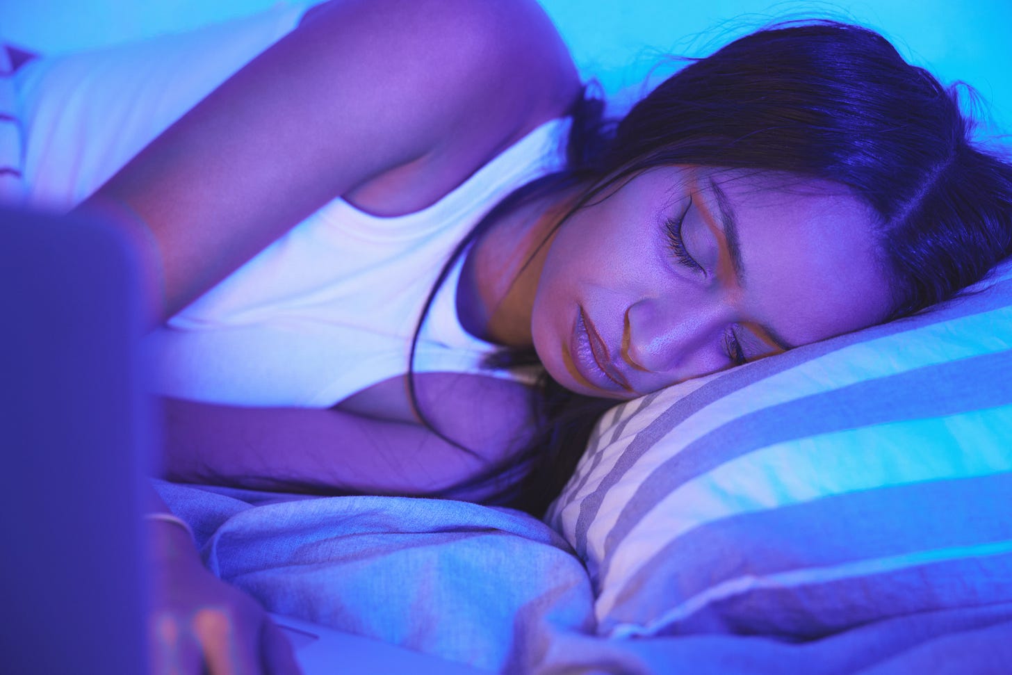 Woman sleeping in the glow of her laptop screen Woman sleeping in the glow of her laptop screen
