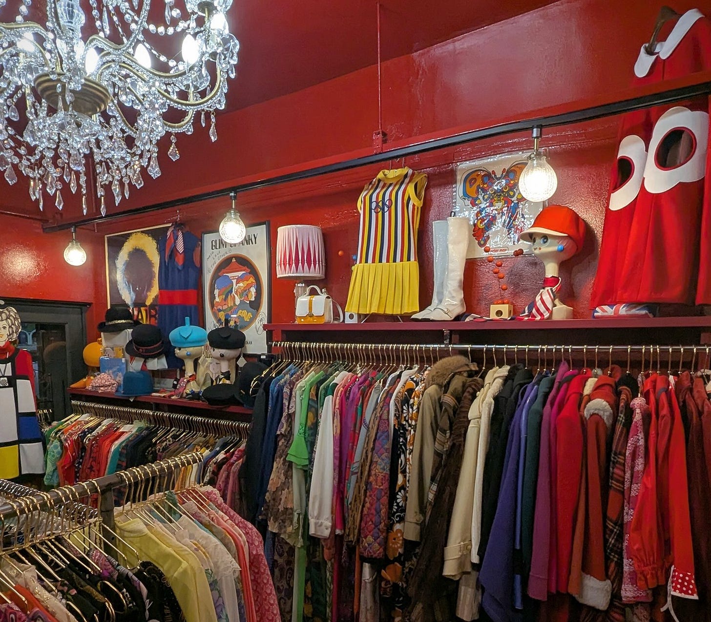 Racks of colorful vintage dresses, bright red walls, and a dazzling chandelier adorn the Nagoya vintage clothing boutique The Other.
