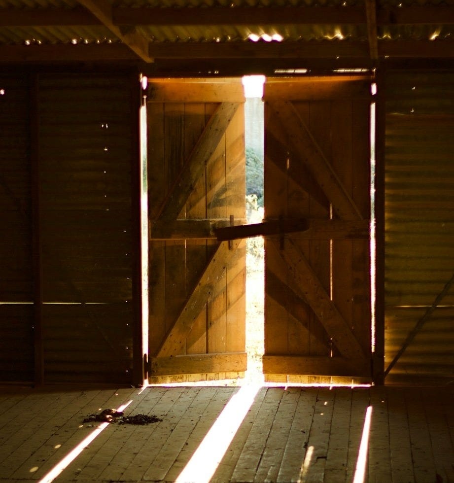 the sun is shining through the open doors of a building