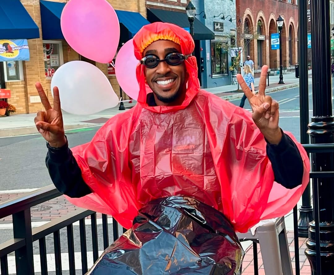 Doughty in goggles and a poncho at a city event
