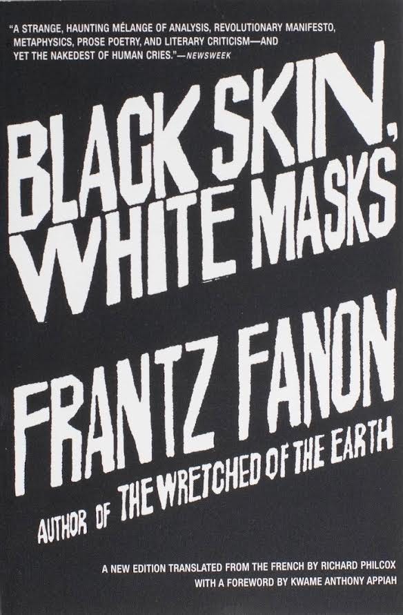 Pictured is a black background with white diagonal font of the title “Black Skins, White Masks”