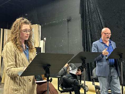 Actors reading a play in a theater.