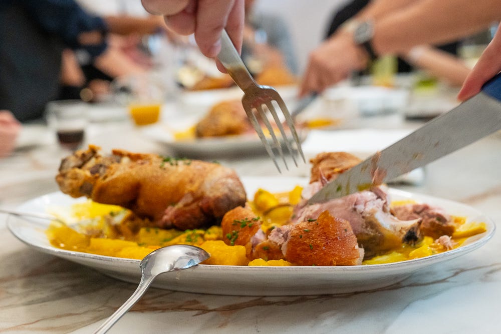 A low perspective of the pork knuckle being carved
