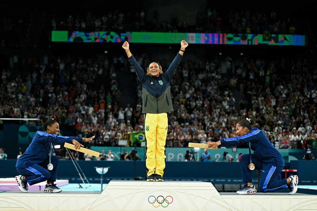 Simone Biles, left, joins teammate Jordan Chiles in pointing toward gold medalist Rebeca Andrade of Brazil. Biles won silver and Chiles bronze in the women's floor exercise at the Paris 2024 Olympic Games — the first time three Black athletes have shared the podium in Olympic gymnastics. Simone Biles, left, joins teammate Jordan Chiles in pointing toward gold medalist Rebeca Andrade of Brazil. Biles won silver and Chiles bronze in the women's floor exercise at the Paris 2024 Olympic Games — the first time three Black athletes have shared the podium in Olympic gymnastics.