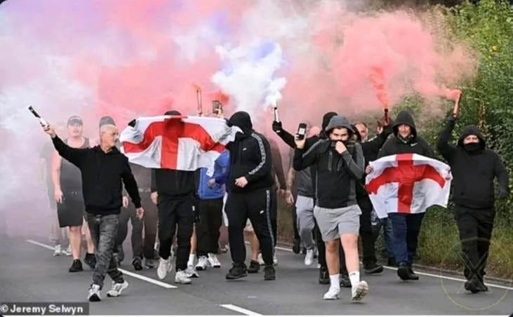 A group of people walking on a road with smoke bombs

AI-generated content may be incorrect.